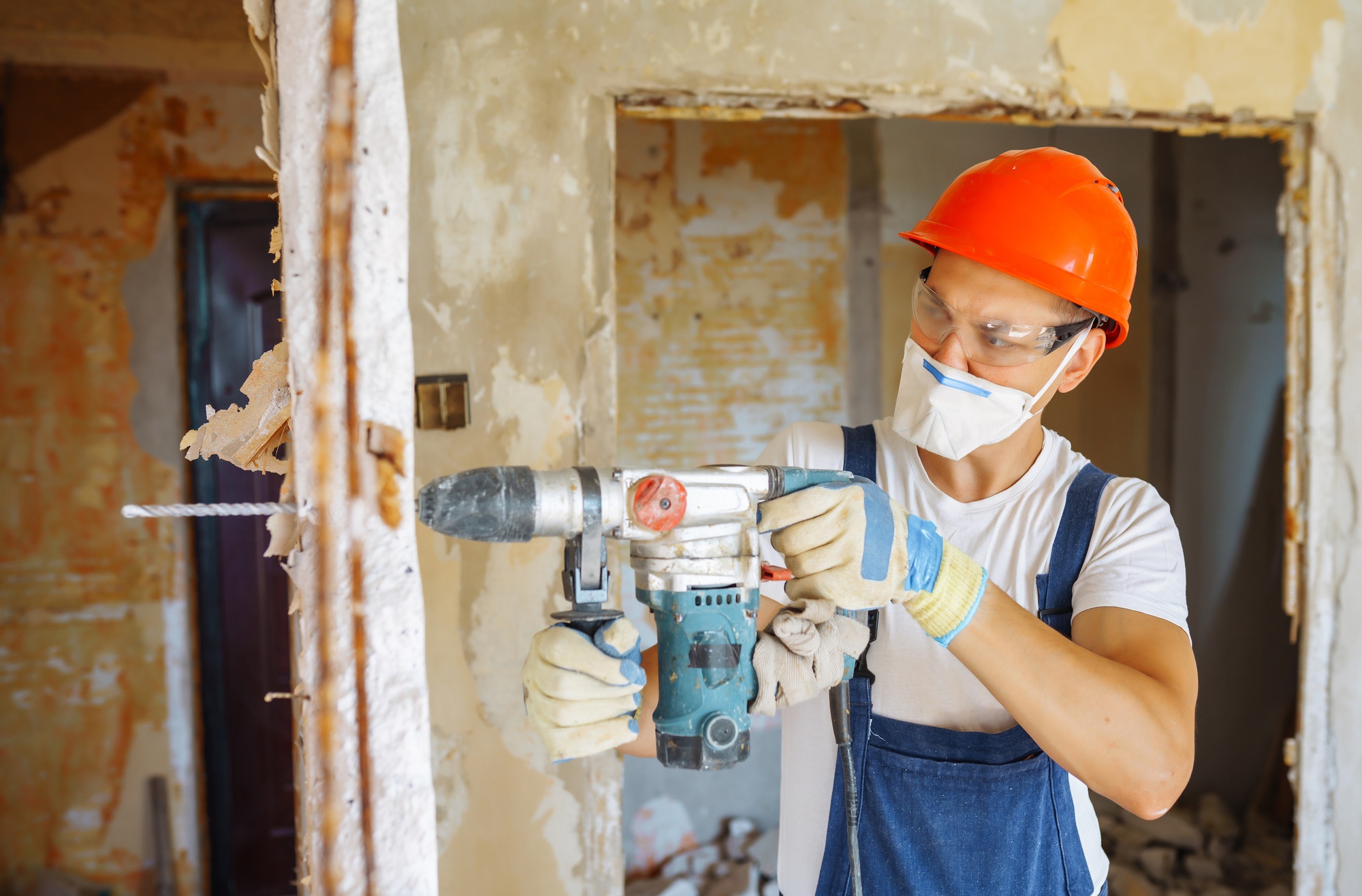 Repairer in boilersuit holding tools. Apartment repair and renovation concept. Building.
